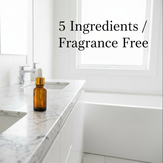 Bathroom with marble countertop, sink, and a bottle of hyaluronic acid seruml.